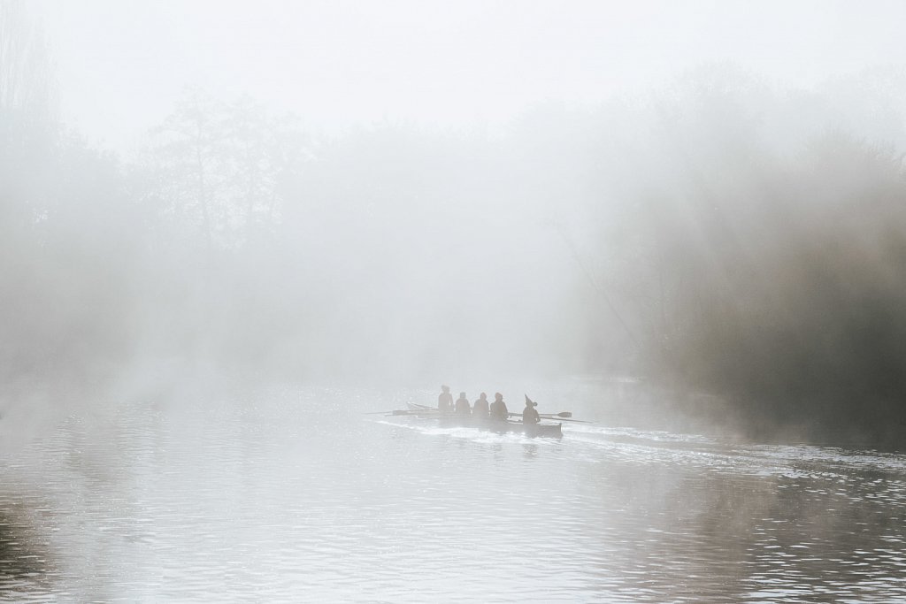 Men on a boat in a foggy morning